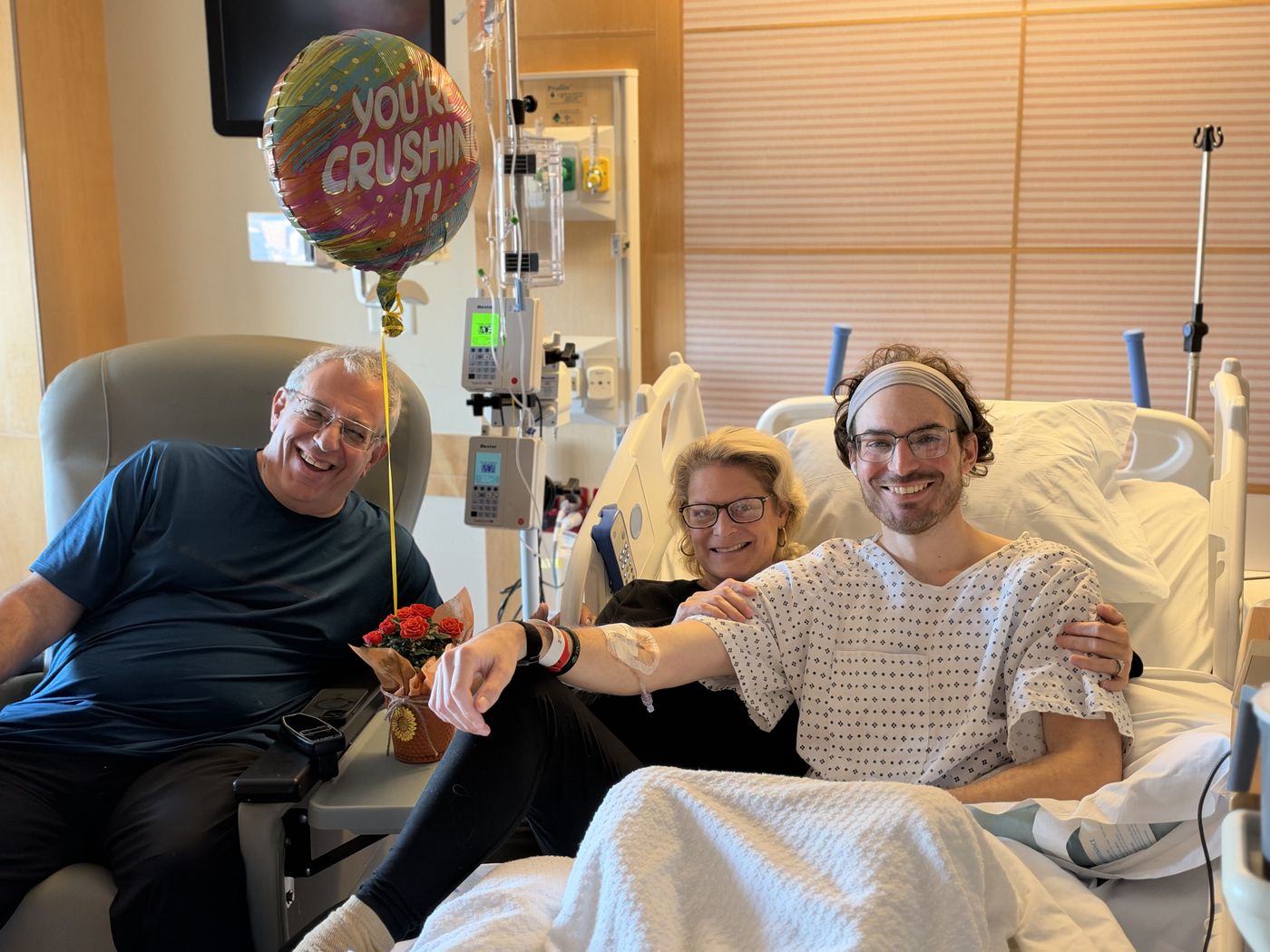 Chris with family beside a balloon that reads “You’re Crushing It”